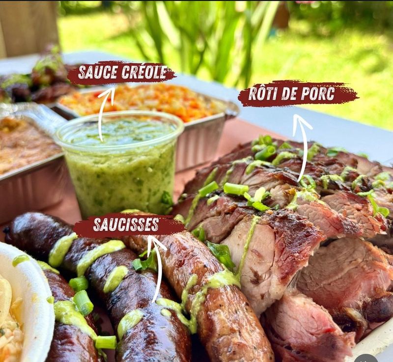Rôti de porc boucané, saucisses et sauce créole servis en extérieur